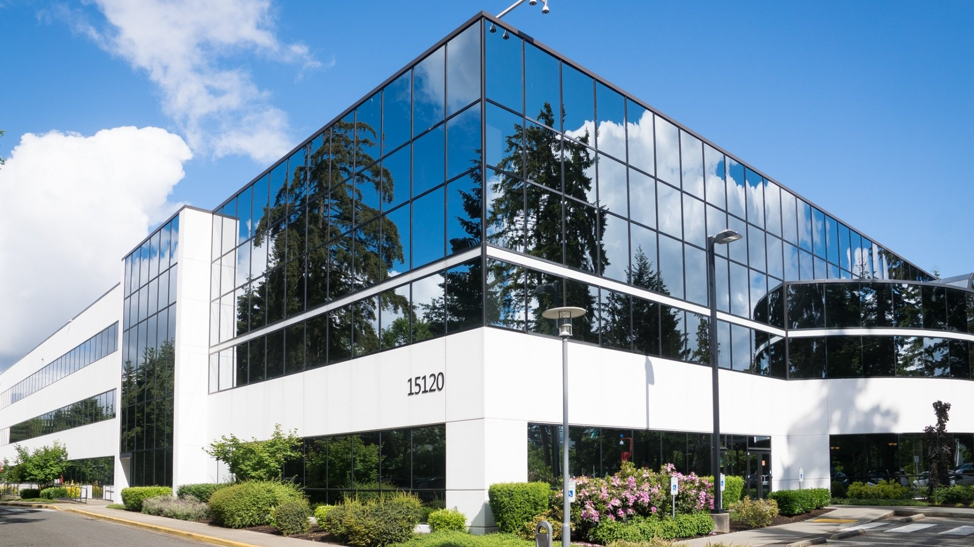 A large office building with a lot of windows on a sunny day.