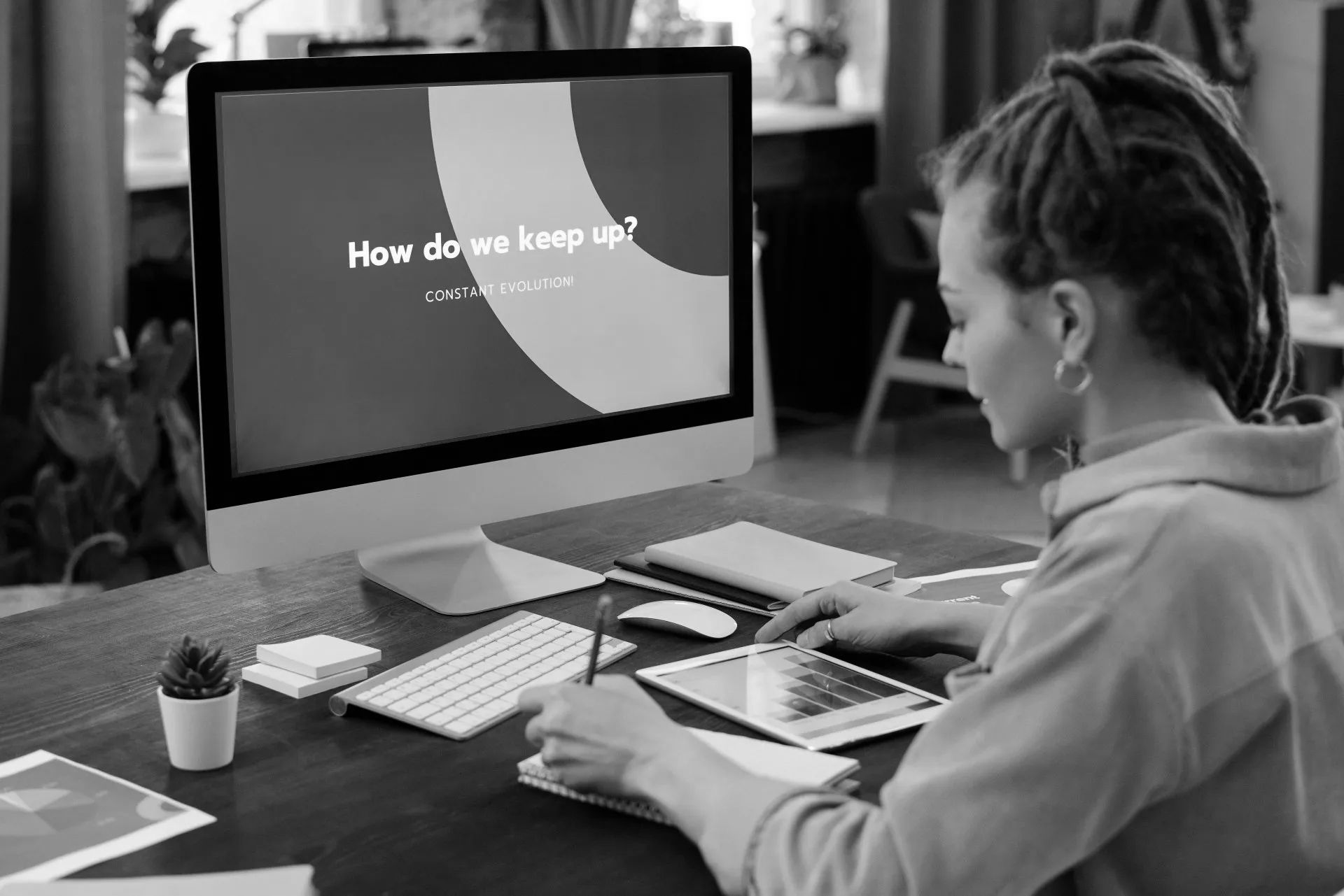 A woman is sitting at a desk in front of a computer.