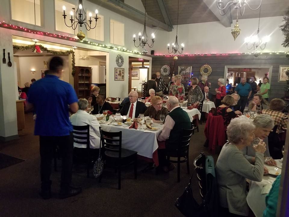 A large group of people are sitting at tables in a restaurant.