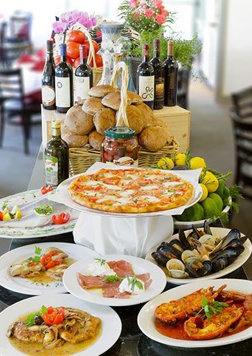 A table topped with plates of food and bottles of wine