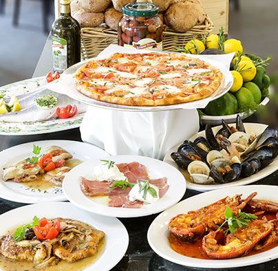 A table topped with plates of food including a pizza