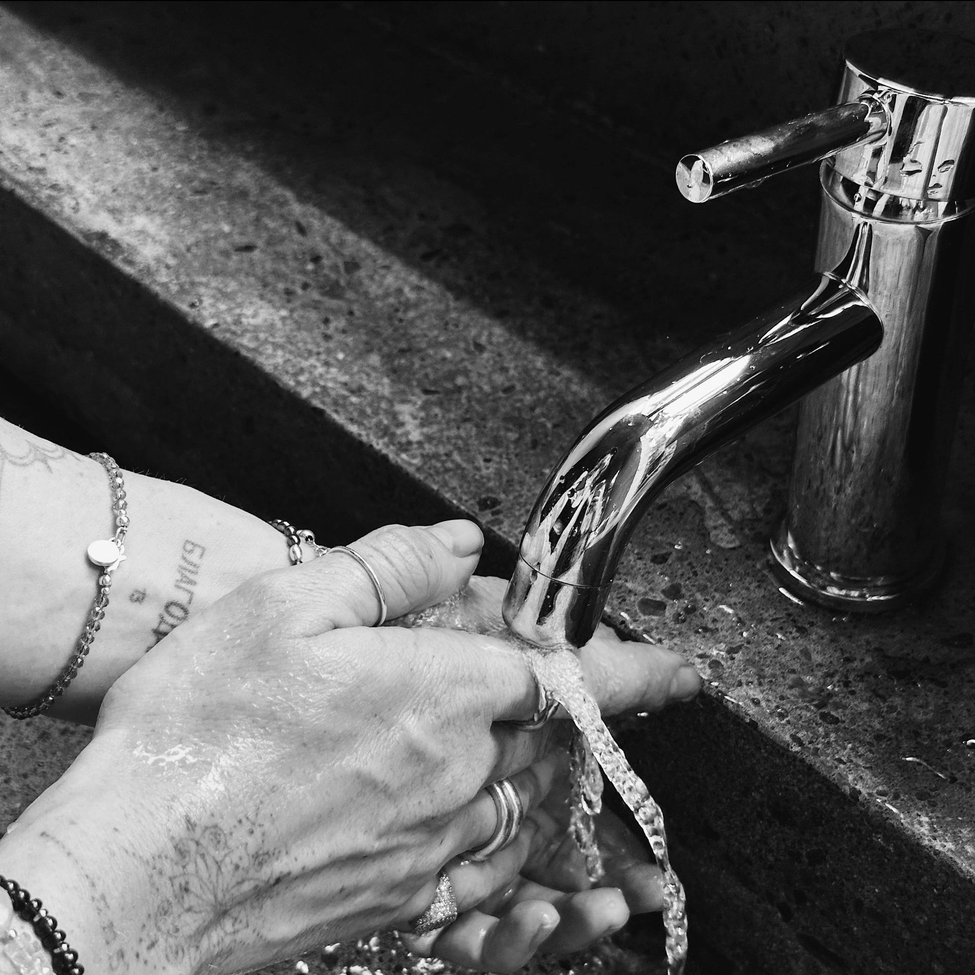 A person is washing their hands under a running tap