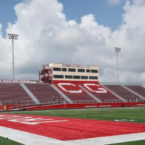 A football field with a building in the background that says cg
