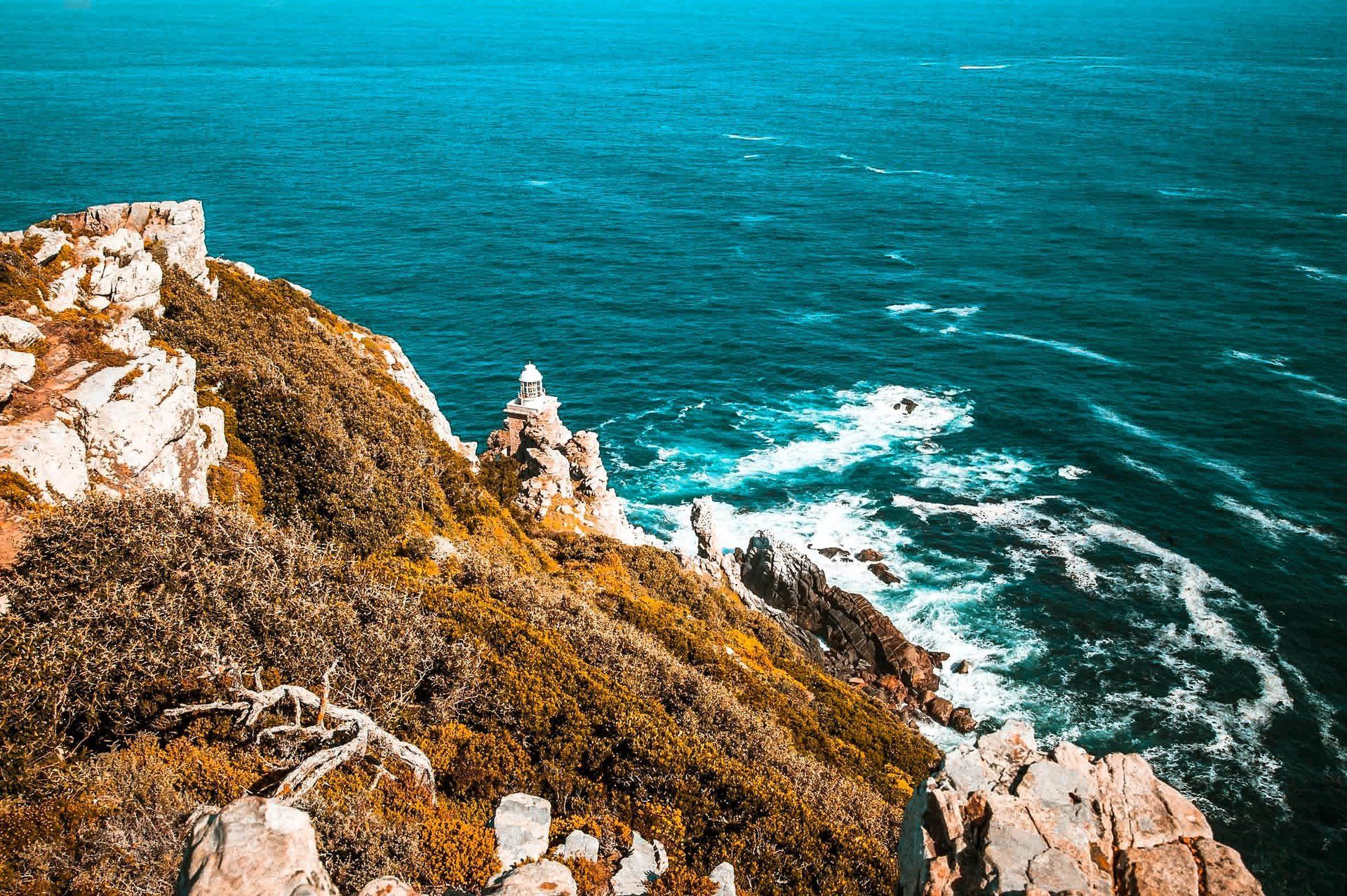 A rocky peninsula juts into the crashing Atlantic surf