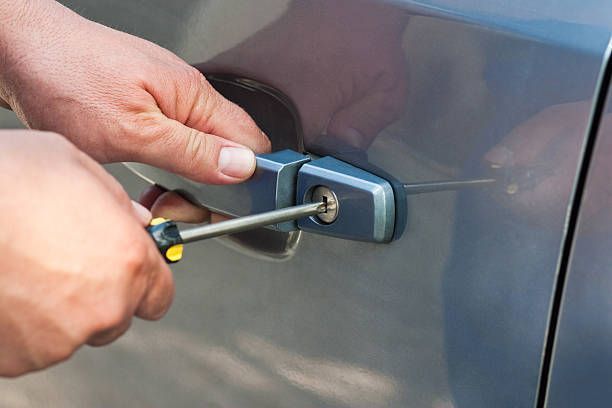 Man opening car door handle, showcasing skills of a car locksmith for vehicle access.
