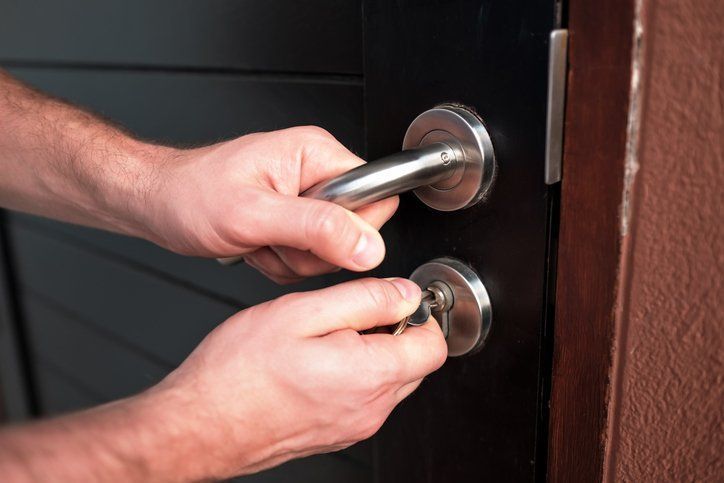Man opening black door — Cerritos, CA — Southern California Security Centers Inc