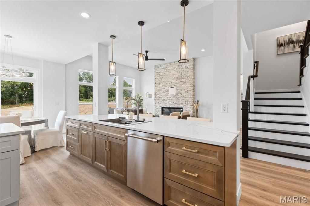 A kitchen with white cabinets and stools and a large island.