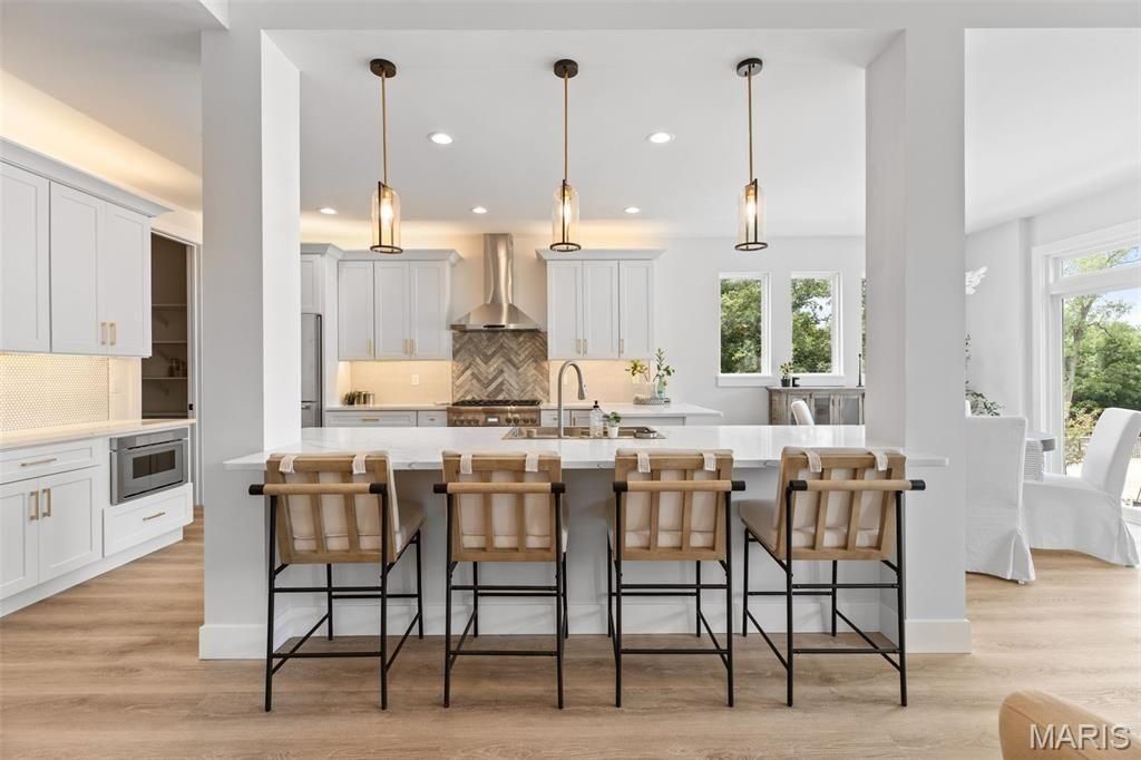 A living room with two chairs and a coffee table with a vase of flowers on it.