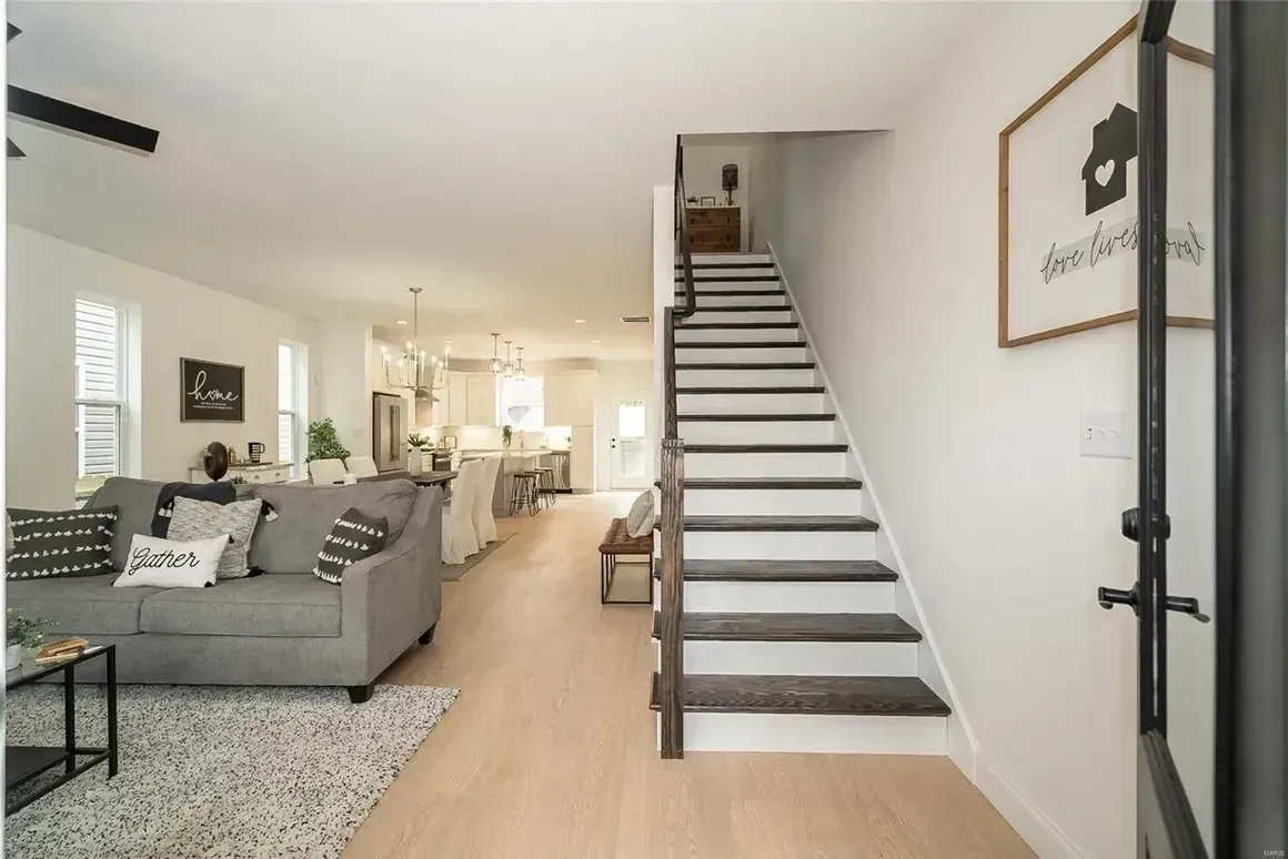 A living room with a couch and stairs leading up to the second floor