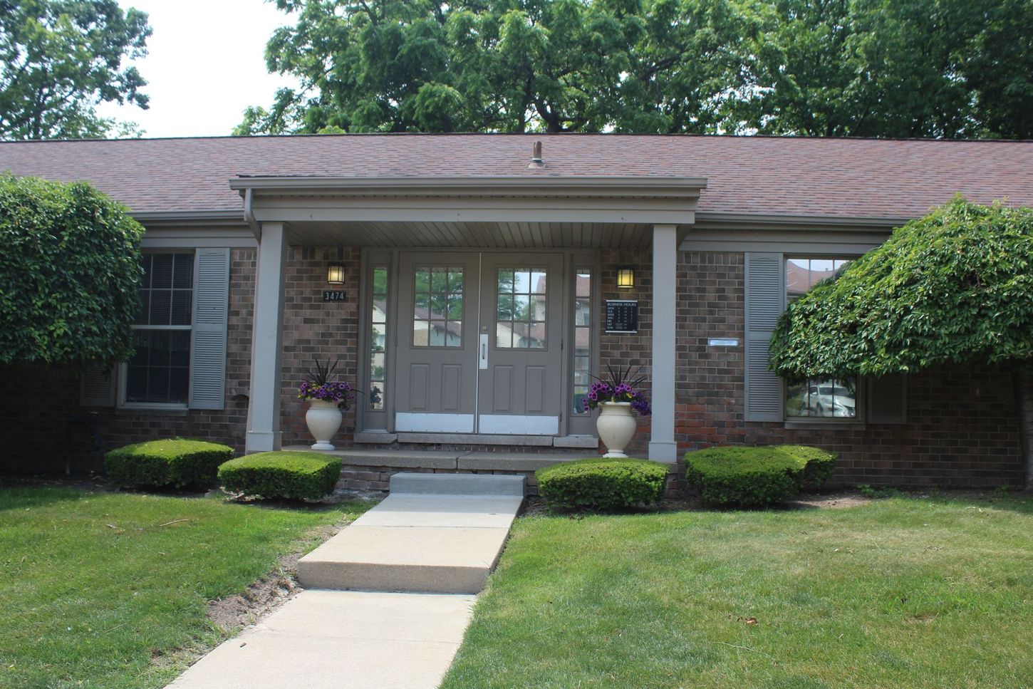 A brick house with a walkway leading to the front door