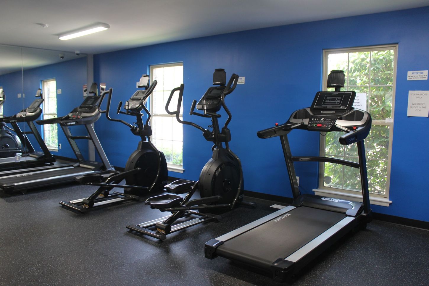 A gym with a lot of treadmills and ellipticals