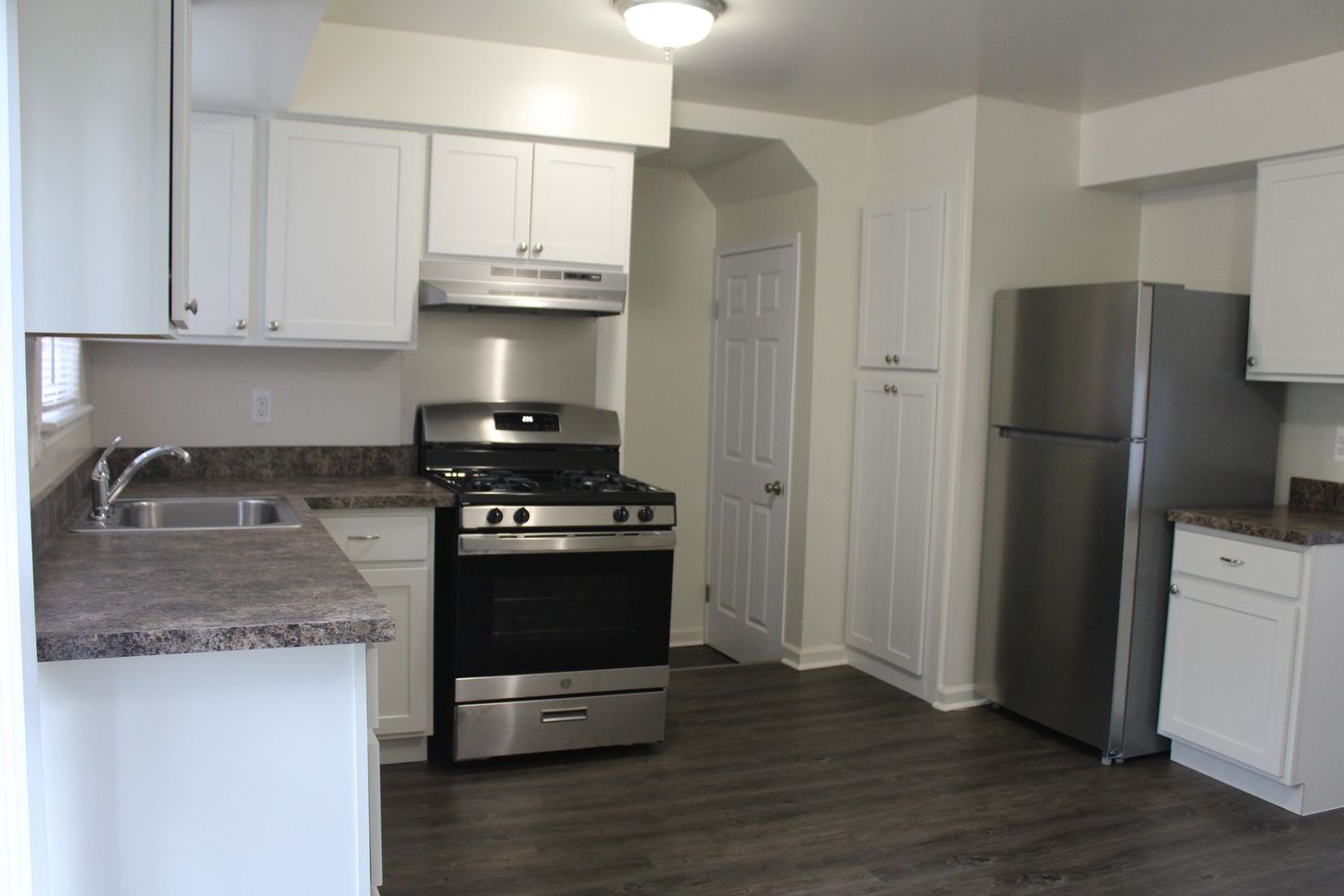 A kitchen with stainless steel appliances and white cabinets