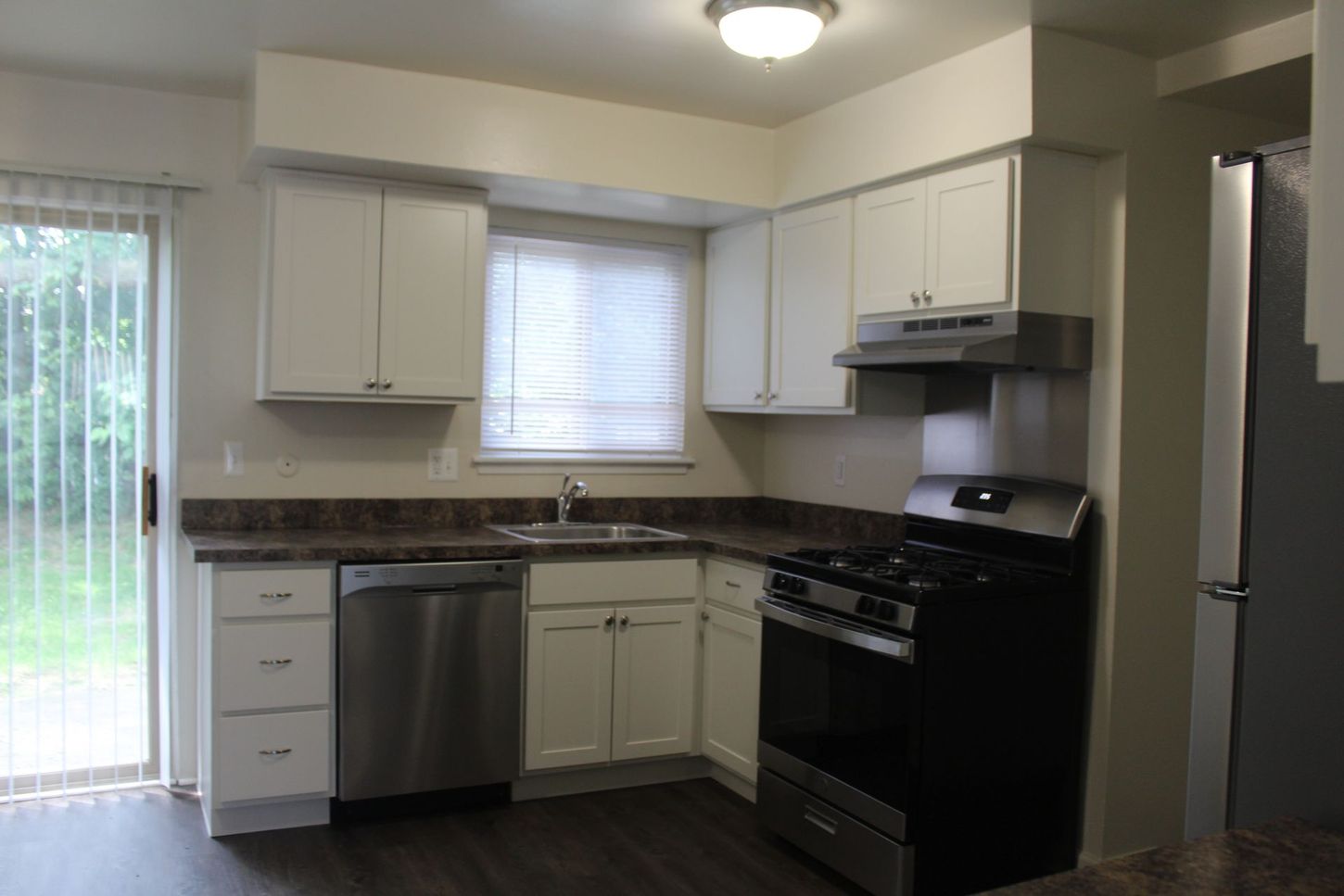 A kitchen with white cabinets and stainless steel appliances
