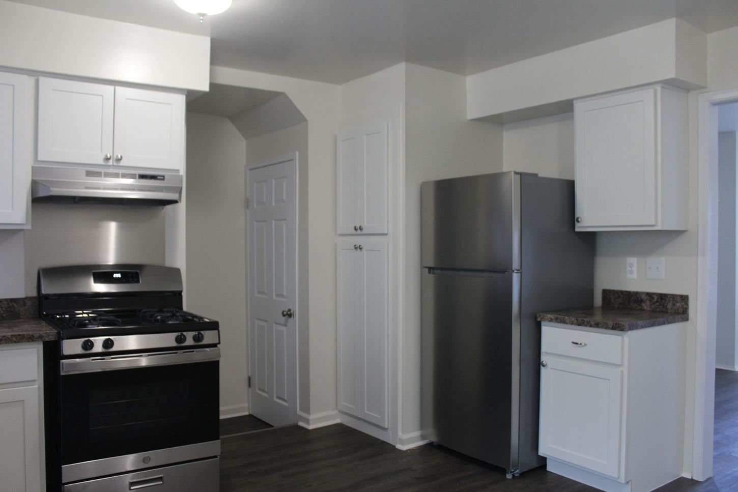A kitchen with stainless steel appliances and white cabinets
