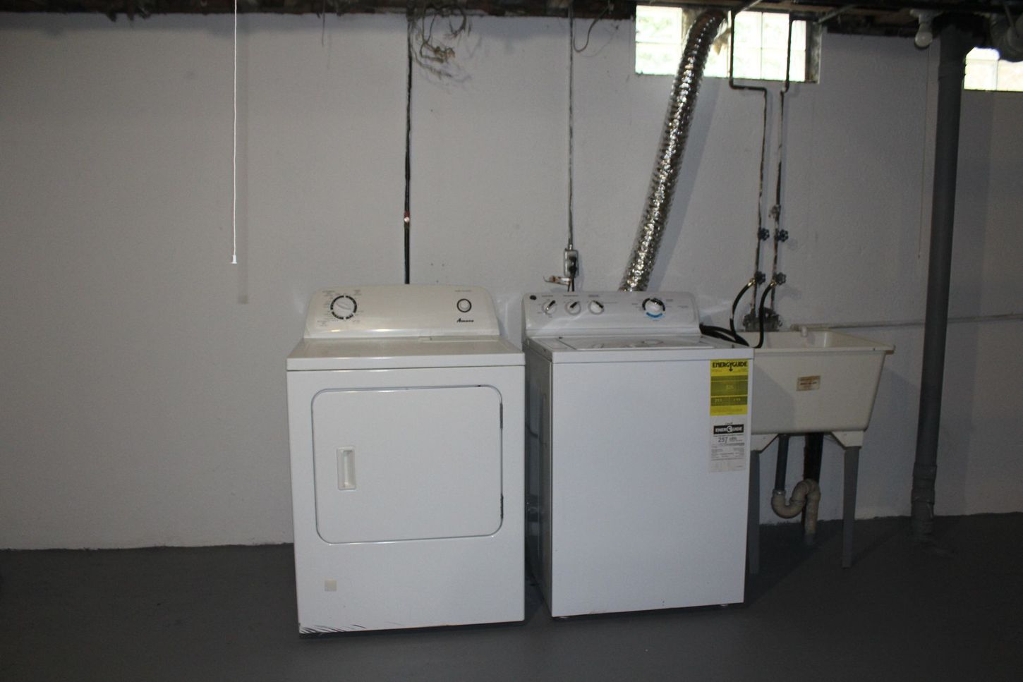 A laundry room with a washer and dryer and a sink.
