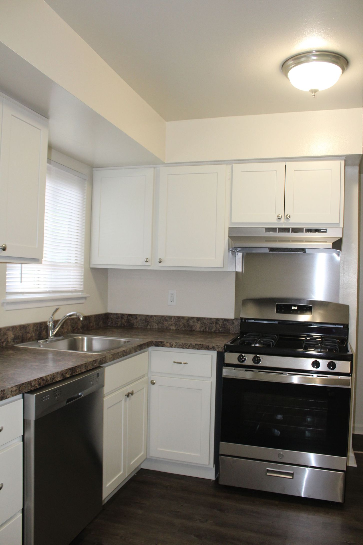 A kitchen with stainless steel appliances and white cabinets