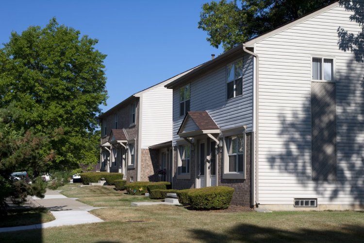A row of apartment buildings with trees in the background