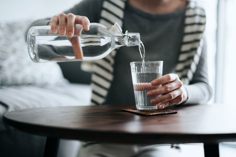 una donna che versa dell'acqua in un bicchiere