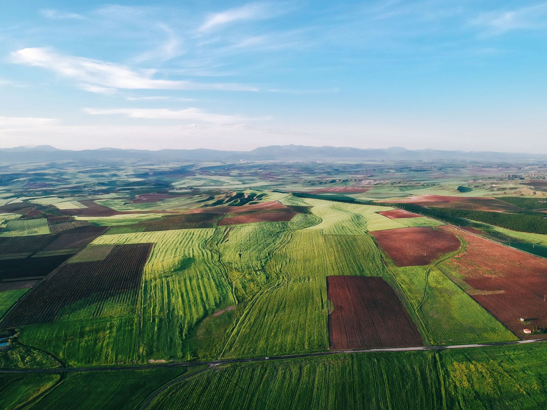 Aerial view of patchwork farmland under a blue sky