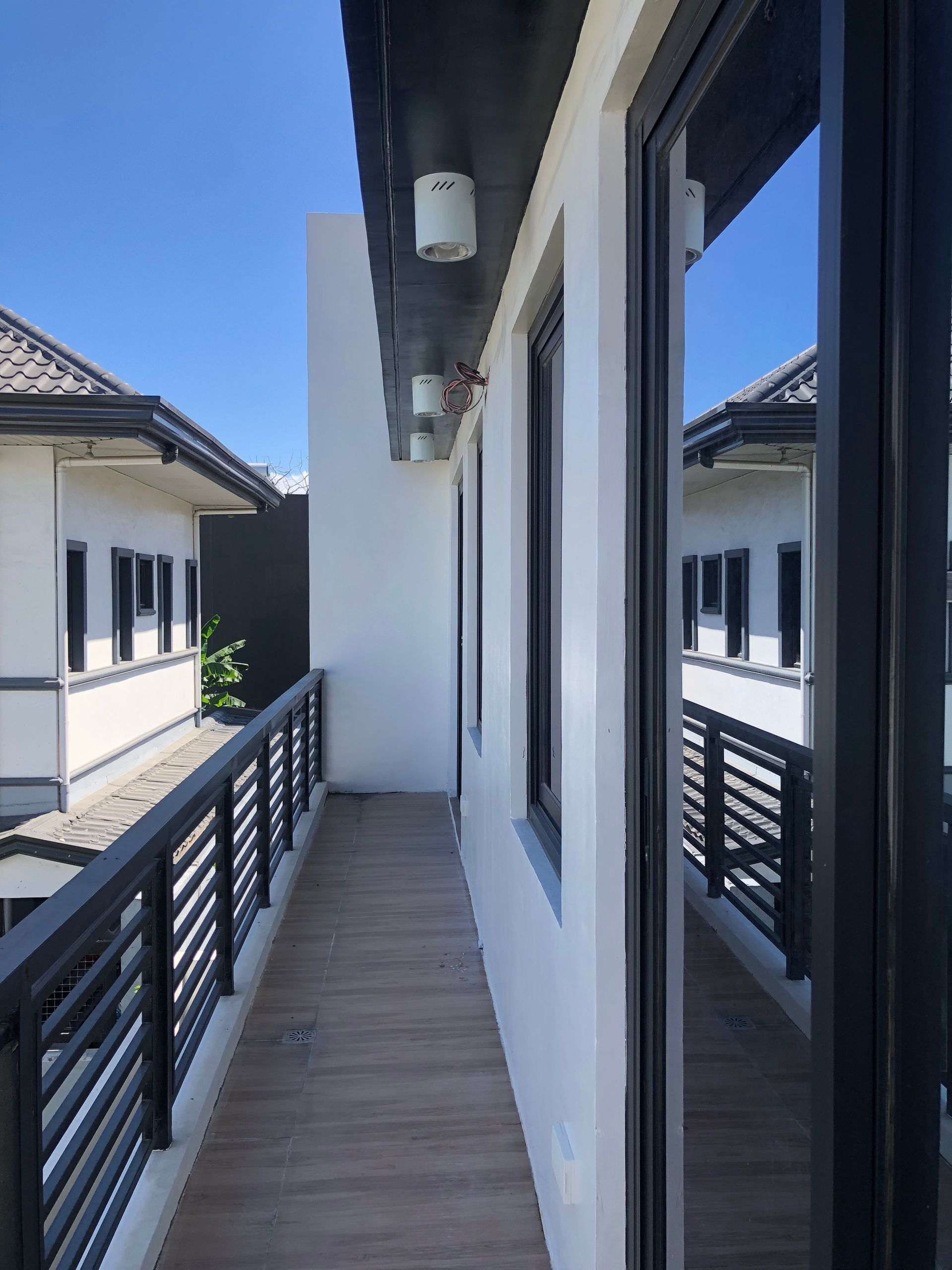 A balcony with a black railing between two buildings