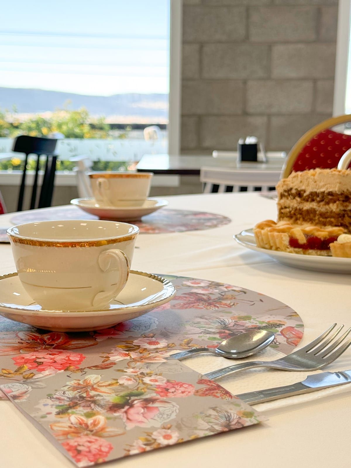 Una mesa con una taza de té y un plato de comida sobre ella.