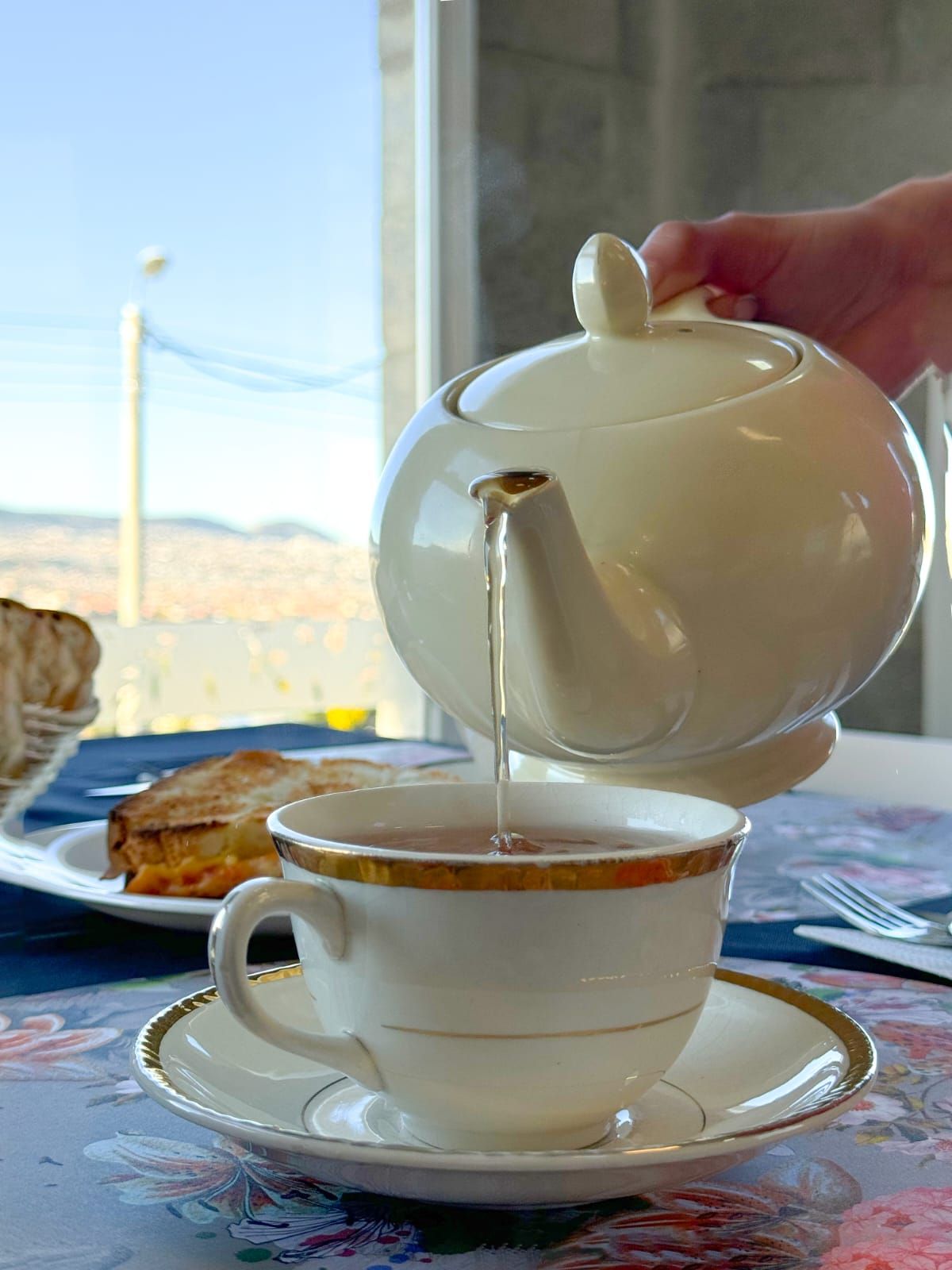 Una persona está sirviendo té en una taza sobre una mesa.