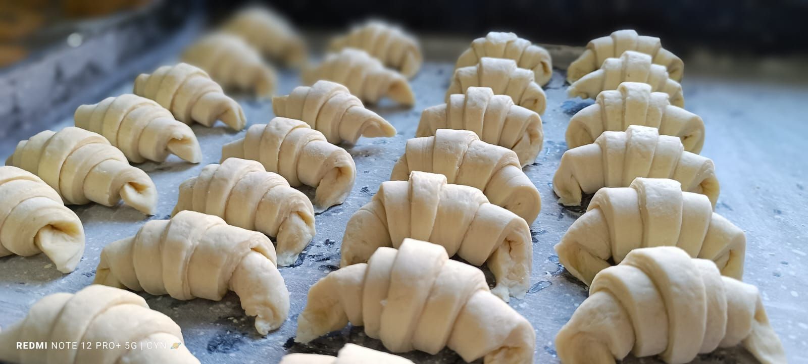 Un montón de croissants están colocados en una bandeja sobre una mesa.