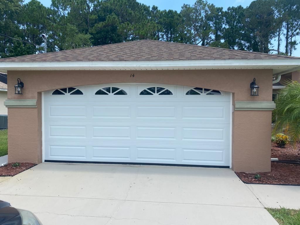 A large white garage door with a brown roof