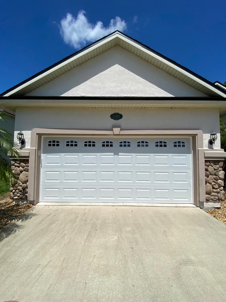 A white house with a large white garage door