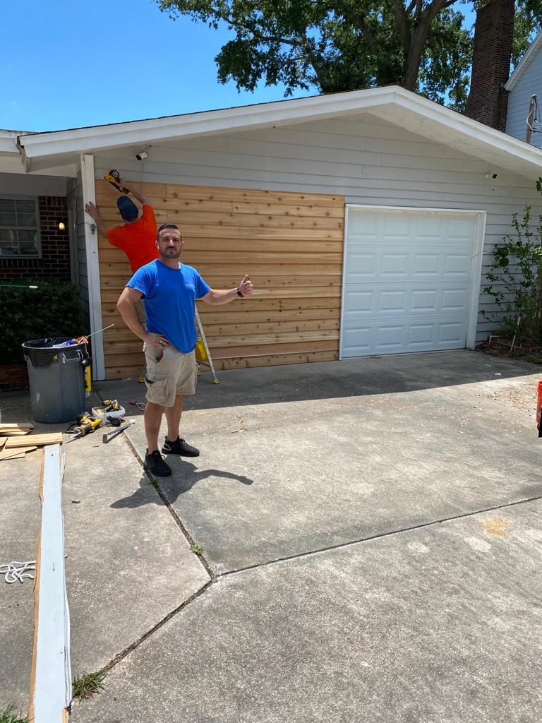 Two men are standing in front of a house that is being painted.