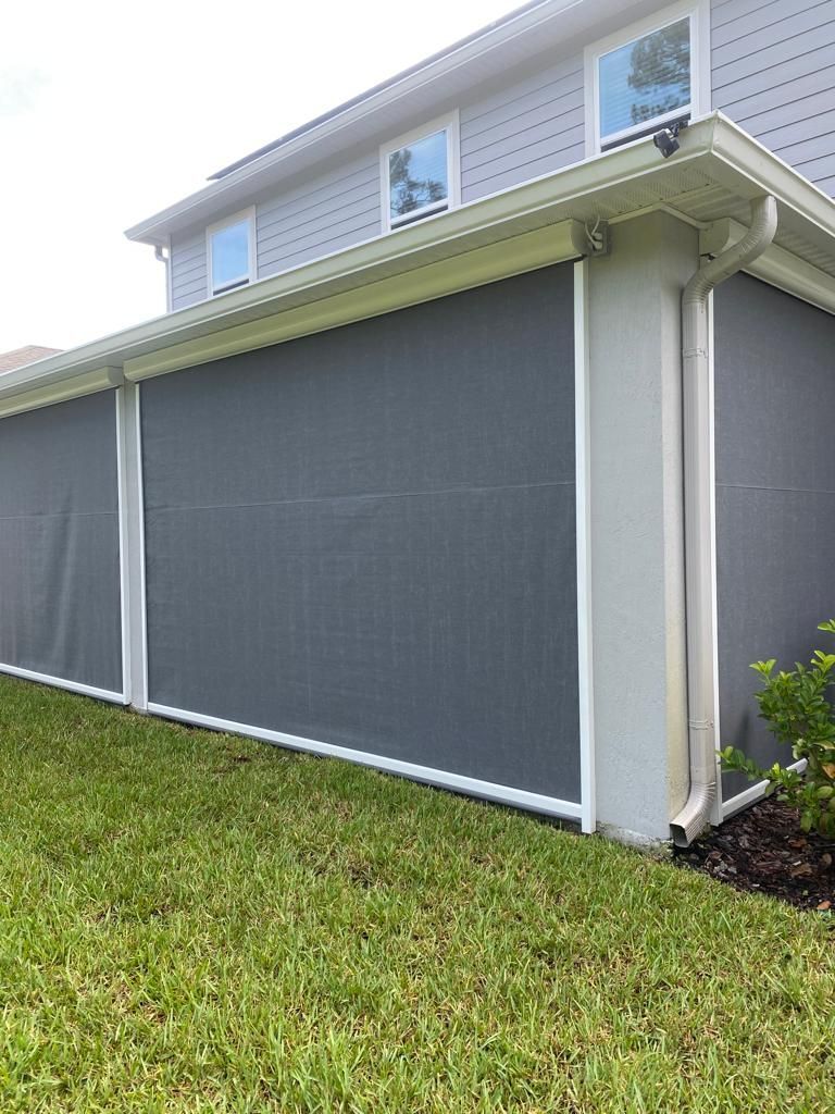A house with a gray screen on the side of it.