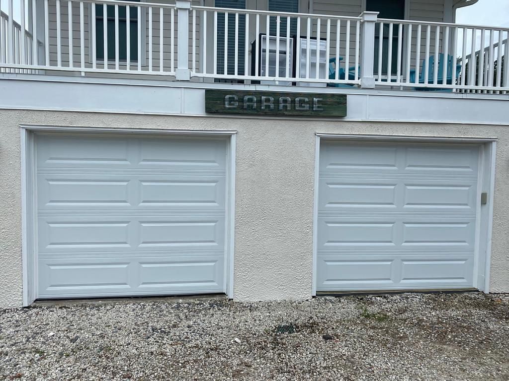 There are two garage doors on the side of a house.