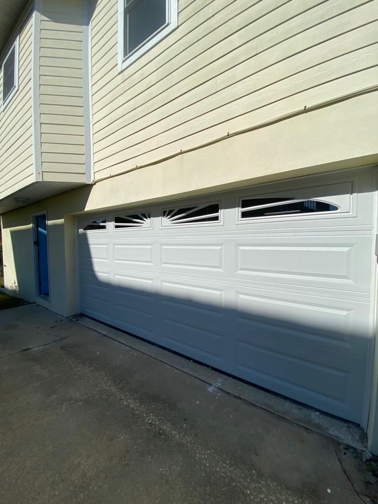 A white garage door is on the side of a house.