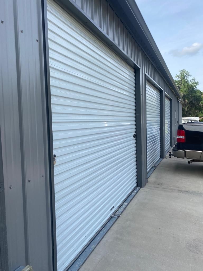 A truck is parked in front of a row of garage doors.
