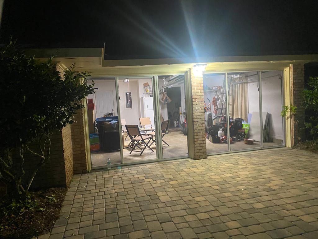 A house with a lot of windows and a patio at night.