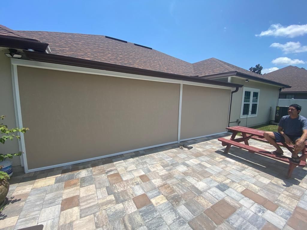 A man is sitting on a picnic table in front of a house.