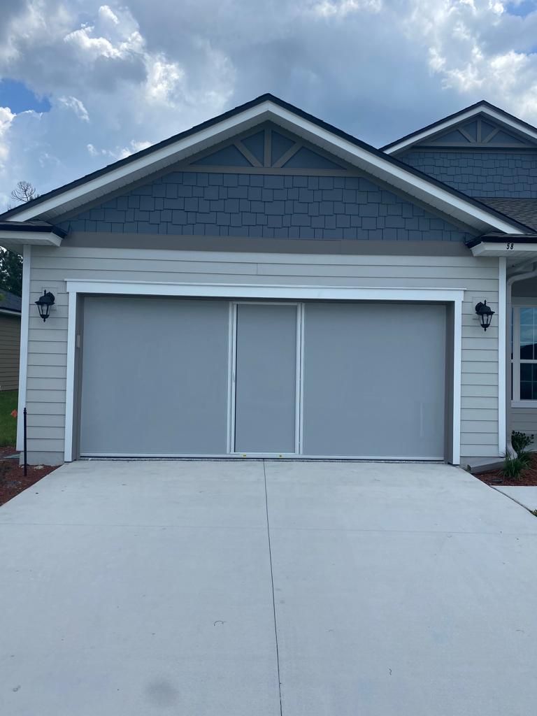 The front of a house with a garage door and a driveway.