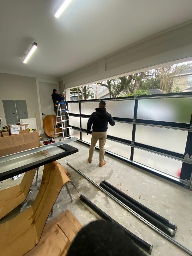 A man is standing in a room holding a piece of glass.