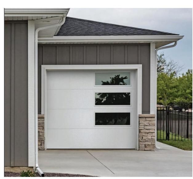 A white garage door is on the side of a house.