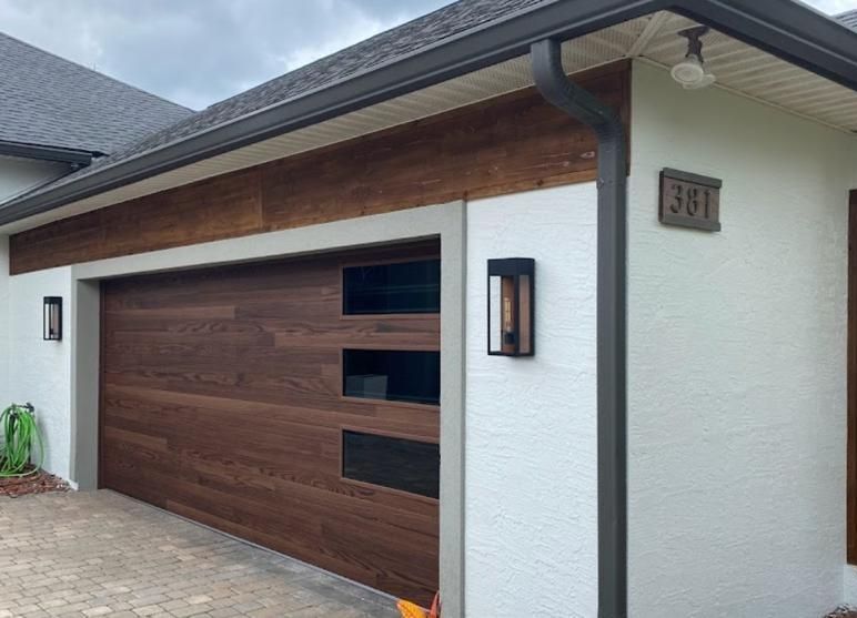 A white house with a wooden garage door.