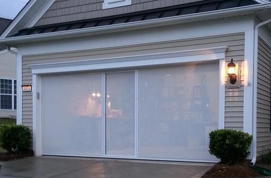 A house with a white garage door and a light on the side of it.