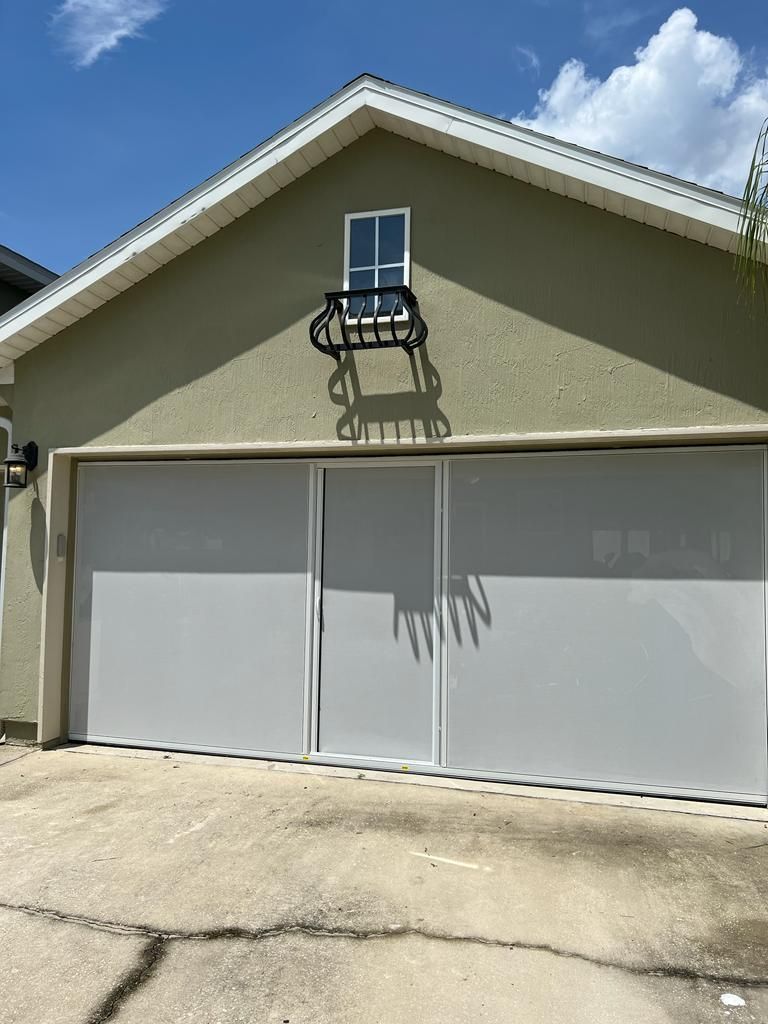 A house with a garage door and a window on the side of it.