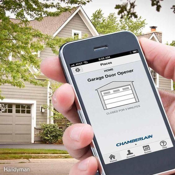 A person is holding a cell phone with a garage door opener app on it