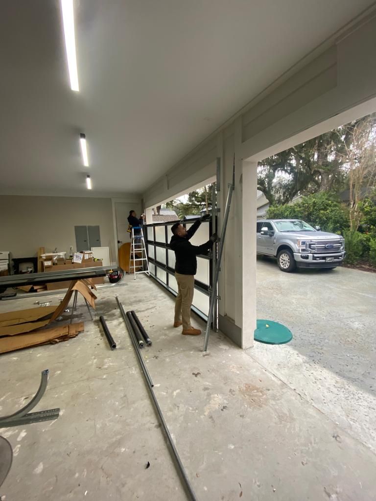 A man is installing a garage door in a garage.