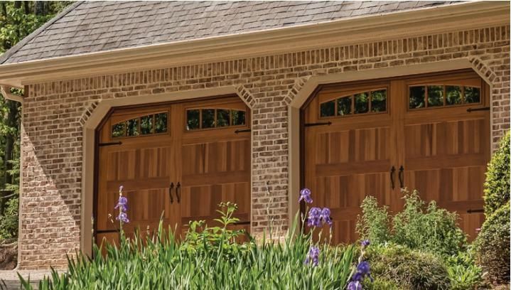A brick garage with two wooden garage doors