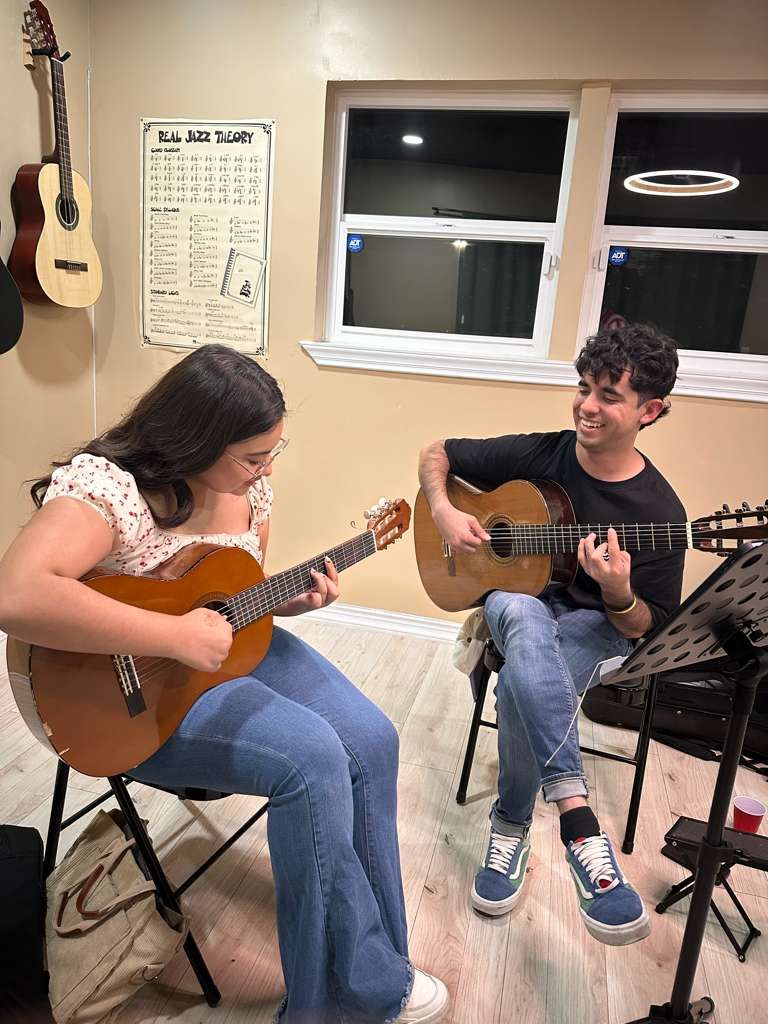 Guitar instructor with student in a lesson.