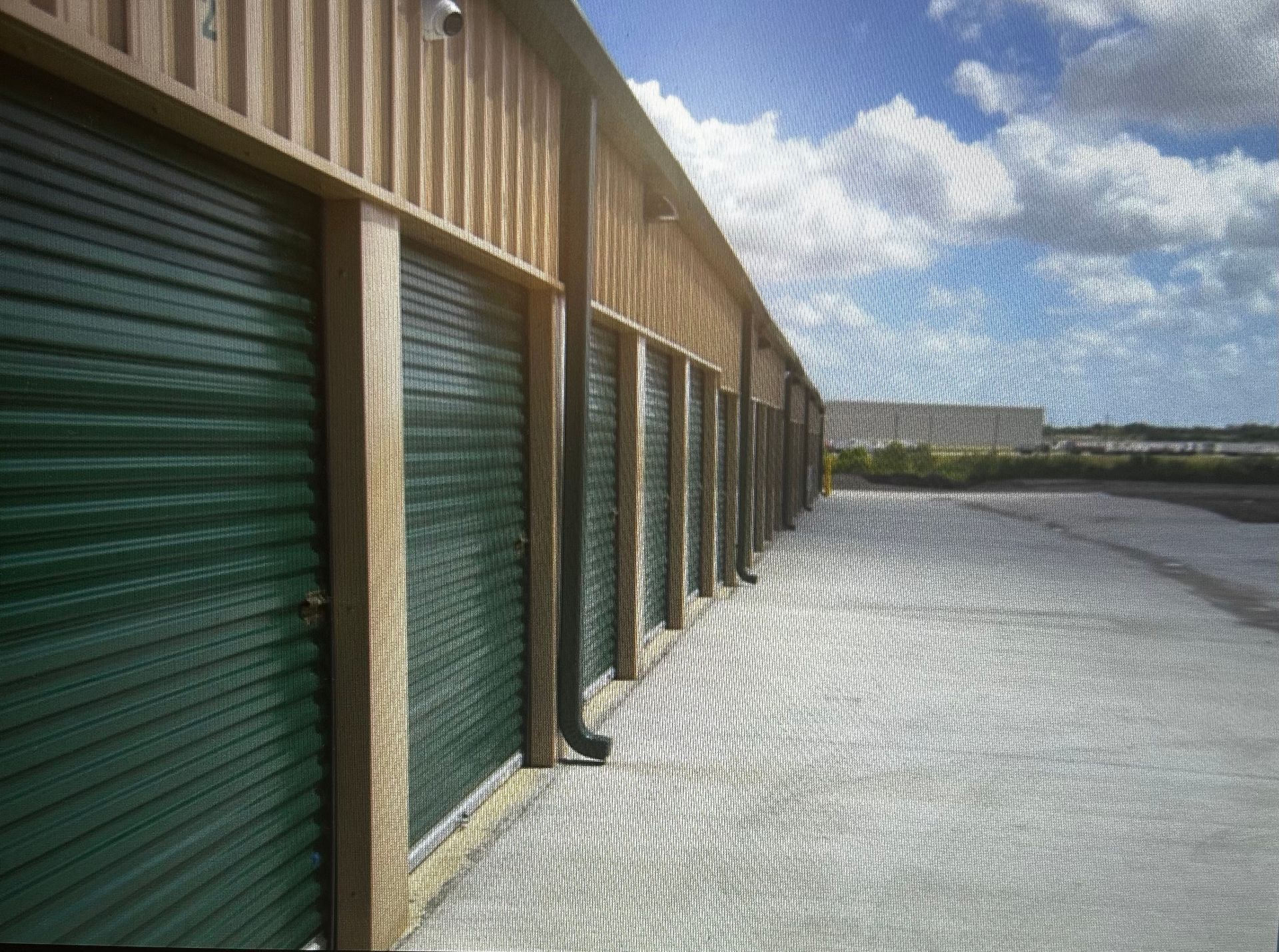 A row of garage doors are lined up in a parking lot.