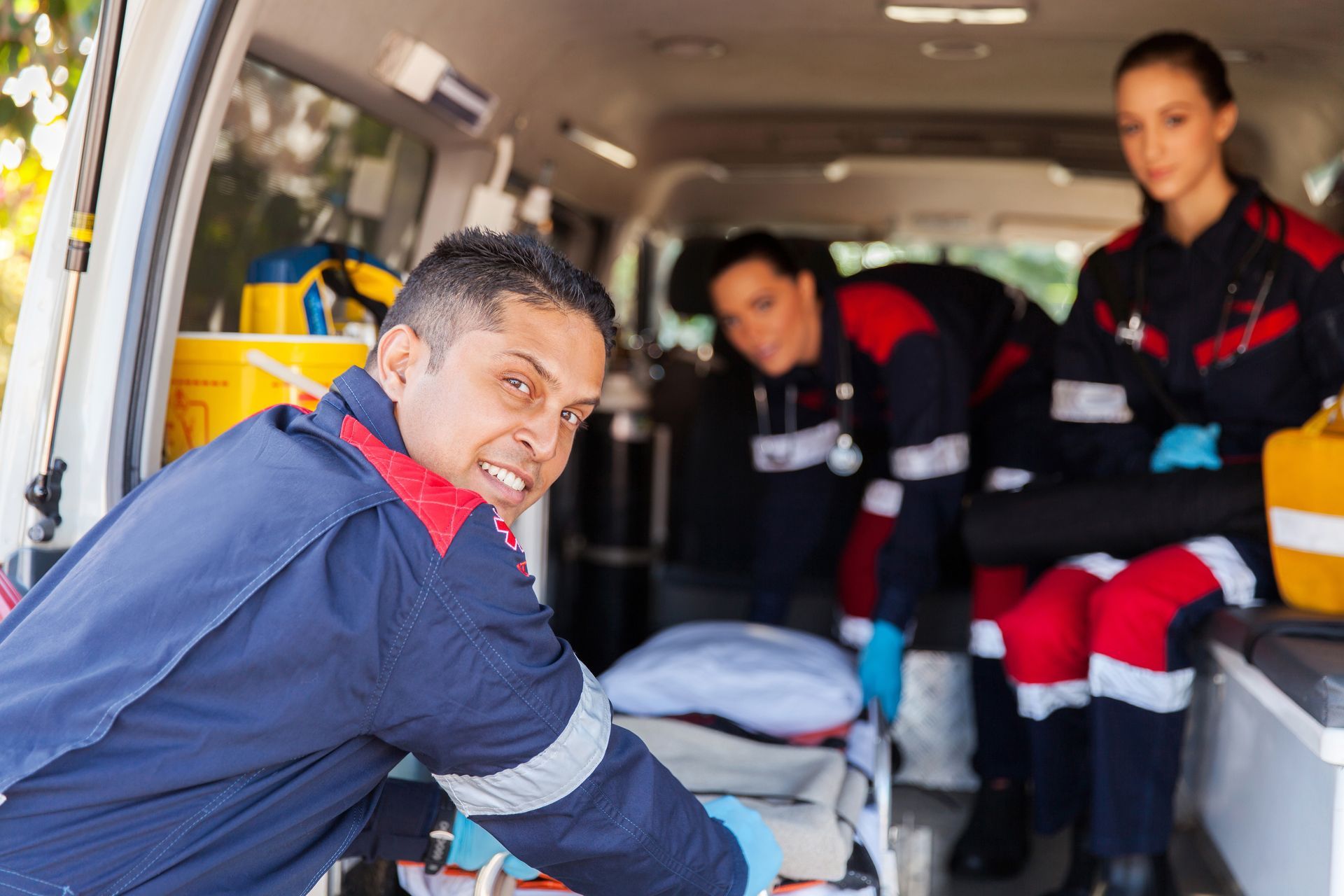 A group of paramedics are standing in an ambulance.