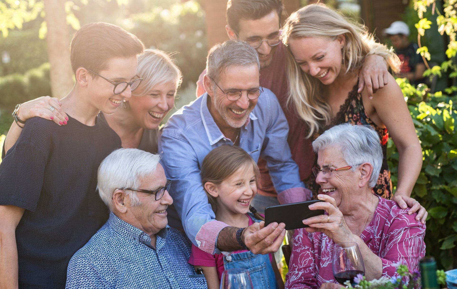 multigenerational family looking at a cellphone smiling