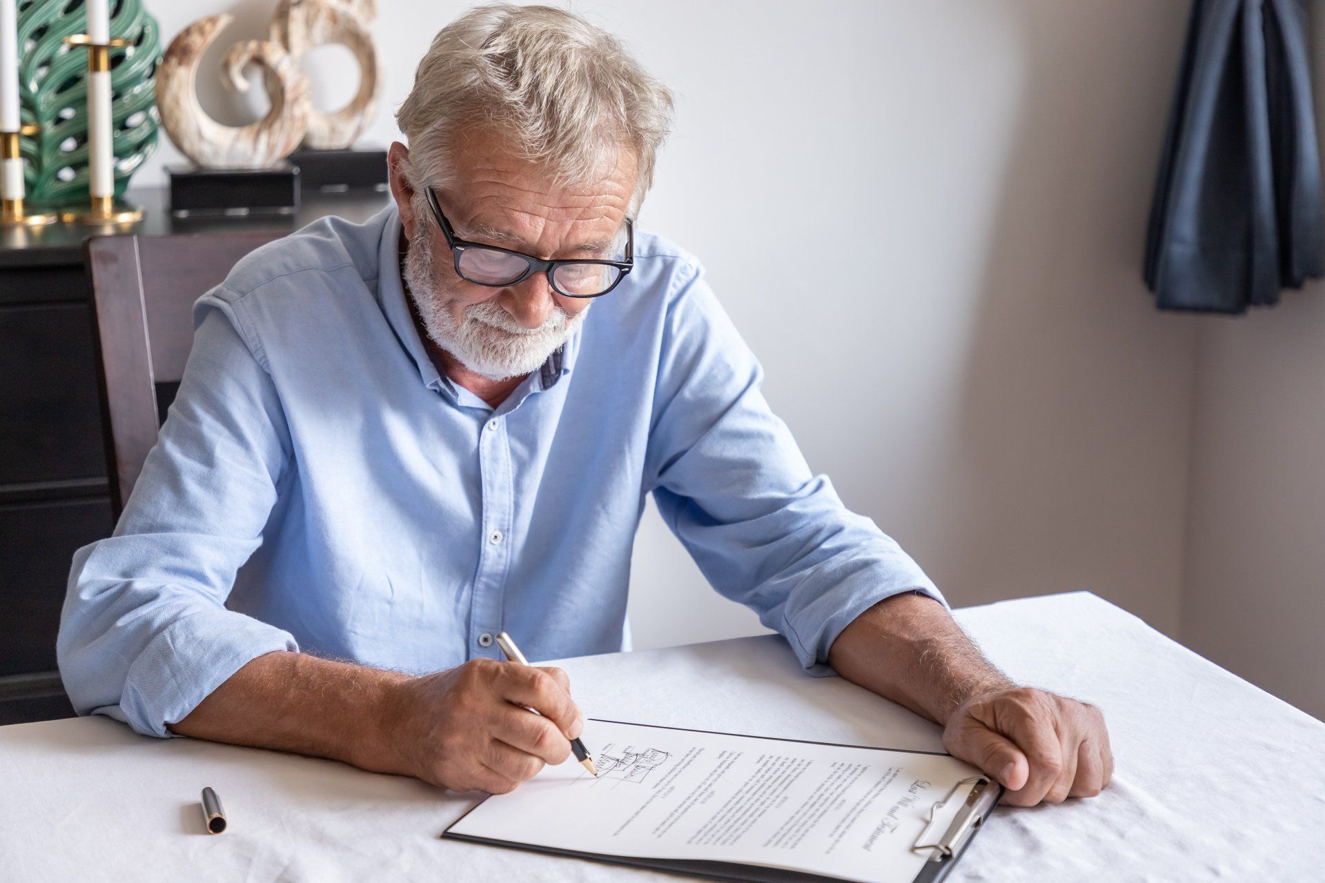 older man signing a formal document